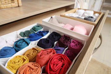 Open drawer with organized clothes in wardrobe, closeup