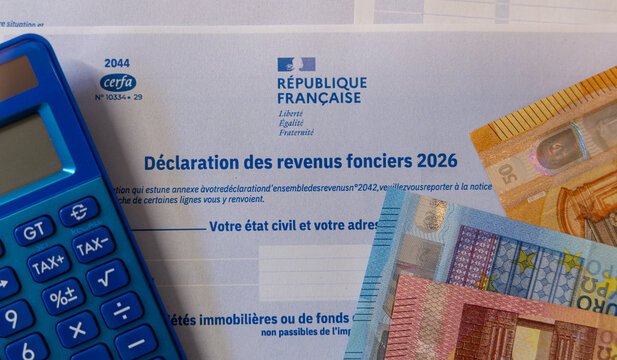 La d&eacute;claration annuelle de 2026 d'imp&ocirc;ts des revenus fonciers avec une calculette et des billets.