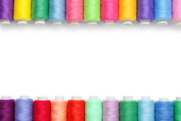 Frame made of colorful thread spools on white background