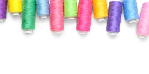 Colorful thread spools on white background