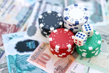 Egyptian pound currency money bills and casino chips with dices. The concept of gambling and poker casino games