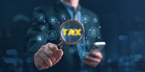 Conceptual image showing a businessman using a magnifying glass to highlight the word TAX surrounded by digital finance icons, symbolizing tax analysis, accounting, and online financial audit systems.