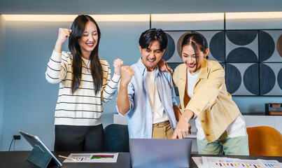 Vibrant business team consisting of diverse individuals joyfully raises their fists in celebration of a significant achievement, Celebrating success in a business team with joyful expressions