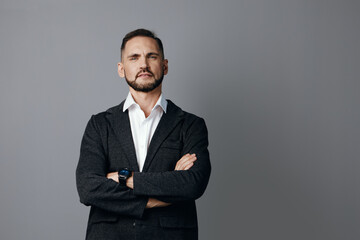 A confident business professional stands against an isolated colored backdrop, arms crossed, conveying determination and focus in a stylish corporate portrait.