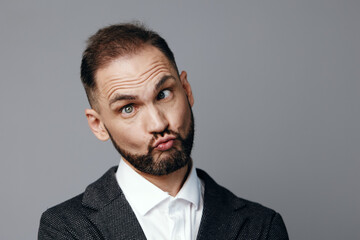 A professional business man stands before an isolated colored backdrop, projecting confidence with a hint of puzzled curiosity, suggesting thoughtful decision making.