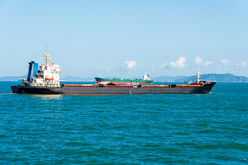 Majestic Cargo Ship Navigating Through Tranquil Waters Under Clear Blue Skies
