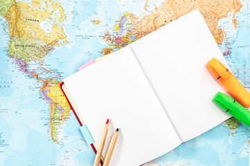 Notebook with mock up page, notebook and textbooks on the world map. Concept of world economy and geography, resources, ecology.. © TSViPhoto