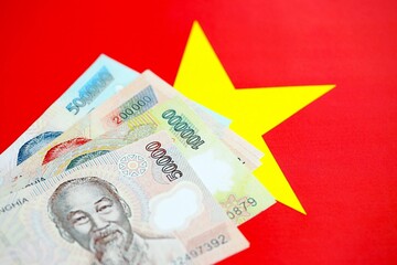 Vietnamese dong currency money bills lies on flag close up. The concept of business and investment