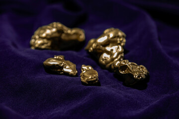 Gold nuggets on velvet fabric. Wealth, investment, luck and success concept