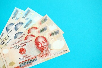 Vietnamese dong money bills in big amount close up on blue. Finance and banking concept