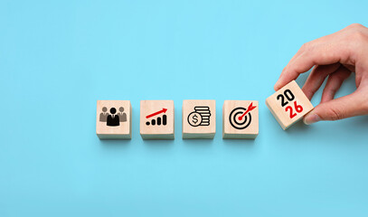 2026 business strategy planning concept with hand placing wooden blocks showing icons of team,...