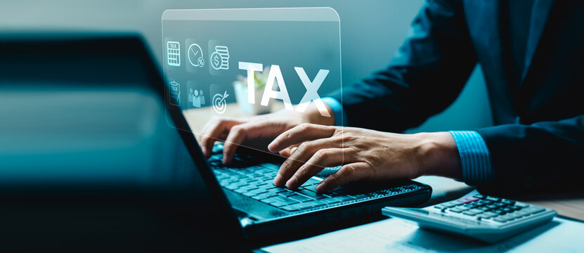 Businessman working on laptop with tax icon, digital taxation, financial report, accounting, online tax filing, business finance management, and electronic tax calculation concept