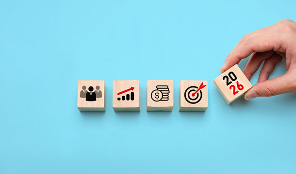 2026 business strategy planning concept with hand placing wooden blocks showing icons of team, growth, finance, and target, symbolizing future goals, leadership, development, and success planning - Powered by Adobe