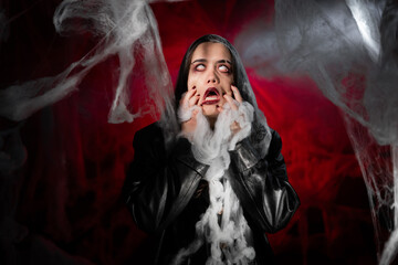 gothic woman with creepy vampire makeup trapped in spider web. Fantasy scary girl on halloween...