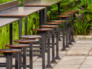 Modern Outdoor High Table and Stools with Lush Green Foliage