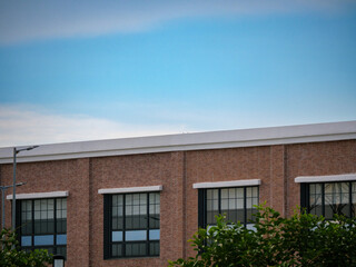 Minimalist View of Red Brick Wall and Industrial Windows Against Blue Sky