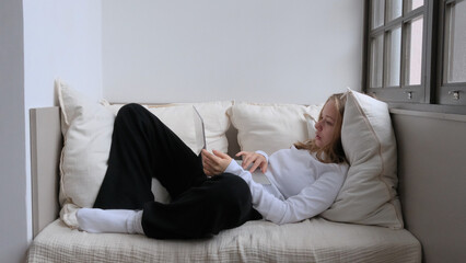 young woman with laptop on sofa