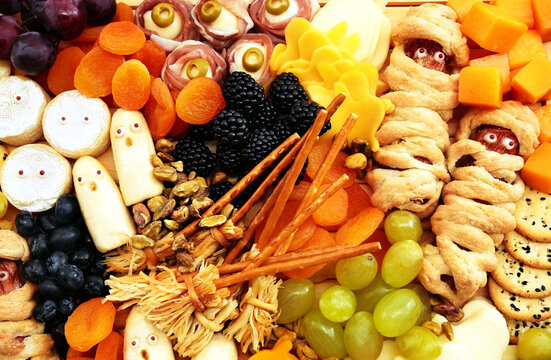 Healthy Halloween fun food mix: cheese ghosts and mummies, banana ghosts and grapes, blueberries and blackberries. Party spooky snacks for kids