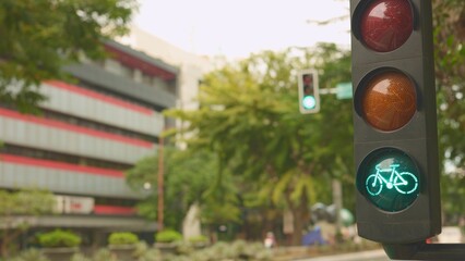 Traffic light green bicycle signal clears path for group riders on city street, small convoy of...