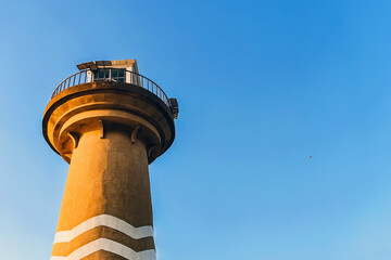 The tower sits on beautiful blue seaside in Bali Hai Cape, Pattaya, Thailand. Beautiful view of public lighthouse on bright sunny day on blue sky background. Bali hai Lighthouse landmark of Pattaya.