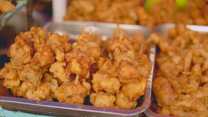 Crispy chicken bites, vendor presenting freshly cooked popcorn chicken, closeup of crispy popcorn chicken served to customers, deliciously crisp popcorn chicken bites being served hot to eager