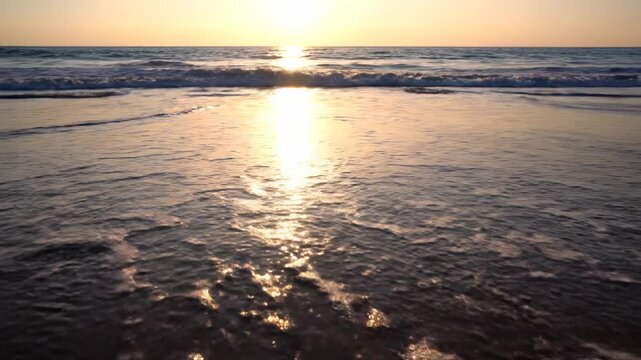 A slow tilt-down reveals frothy ocean waves receding from the wet sand, leaving intricate water trails in the late afternoon light pattern, light, frothy ocean waves