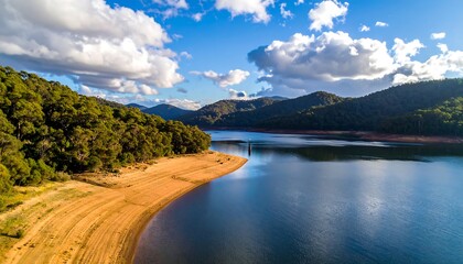 Sunny lake shore, lush forest and mountains