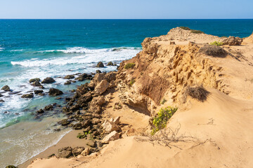 Whimsical white and sandy cliffs on the coast against the backdrop of the turquoise-blue sea and the blue sky