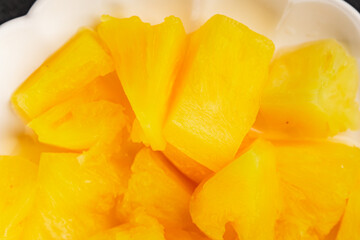 Pineapple canned chunks sweet fruit dessert tasty snack fresh delicious gourmet food background on the table rustic top view copy space keto and paleo diet vegetarian and vegan food
