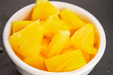 Pineapple canned chunks sweet fruit dessert tasty snack fresh delicious gourmet food background on the table rustic top view copy space keto and paleo diet vegetarian and vegan food