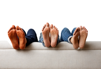 Three pairs of bare feet resting on a light beige couch, against a black background