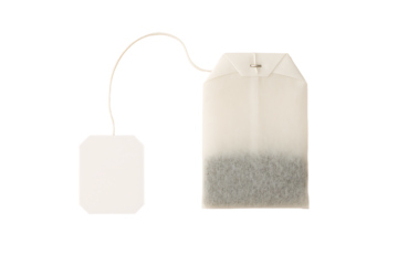 Teabag with white paper tag isolated on black background dry herb bag for brewing hot beverage health concept natural organic drink caffeine infusion breakfast design