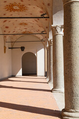 the first floor of an old building with columns  through which sunlight enters