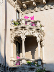 A vintage house with balconies displaying figures of pink dogs. Contemporary urban art 