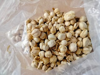 pile of white cardamom in a clear plastic bag