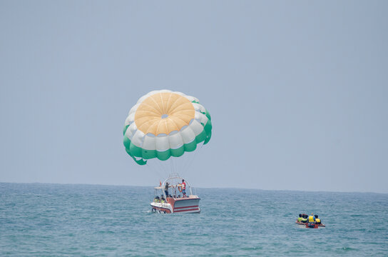 parasailing, which is an aerial sport where a person is towed behind a vehicle, typically a boat, while attached to a specially designed canopy wing at Goa beach activity 