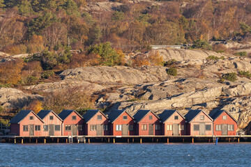 Red beach huts in Sandinavia. Rocky coast and ocean forefront