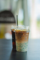 Two glasses of iced coffee on table in coffee shop.