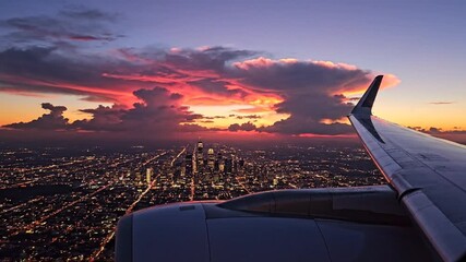Airplane wing view of city lights and a colorful sunset at dusk - Powered by Adobe
