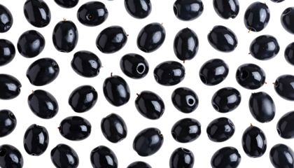 Overhead close-up shot of numerous pitted black olives scattered on a dark background