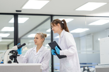 Obraz premium Female scientists in laboratory examining samples with microscope during research project
