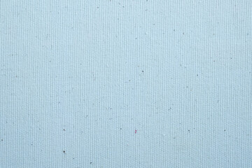 Light blue textured canvas background with small specks

