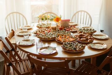 Festive table set with plates and appetizers surrounded by chairs