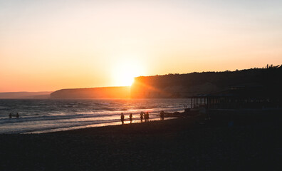 Tourists enjoying sunset at Kourion beach in Cyprus