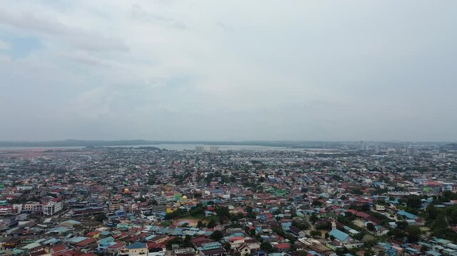 Elevated perspective revealing a sprawling cityscape with countless homes by a serene bay