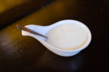 Ceramic dip bowl full of mayonnaise isolated on white. High quality photo