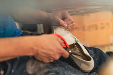 Detail of a shoemaker's hands repairing shoes