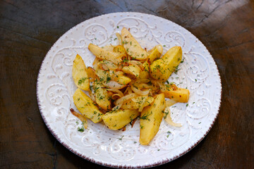 Oven baked potato wedges with sauce over light stone background. Top view, flat lay. High quality photo