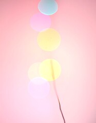 Abstract image of blurred, colorful circular lights against a pink background