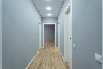 stylish corridor glimpse, contemporary hallway with lighting, sleek gray corridor extends into distance, modern hallway view featuring recessed lighting and elongated perspective